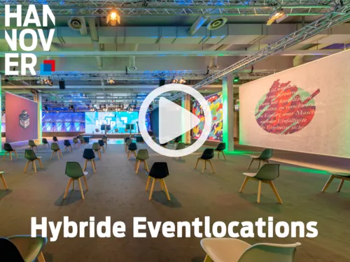 Moderner, farbig beleuchteter Eventraum mit vereinzelten Stühlen, großer Leinwand und kreativer Wandgestaltung.